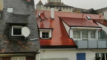 Ein Gebäude mit rotem Ziegeldach, weißer Fassade und blauen Fensterläden.