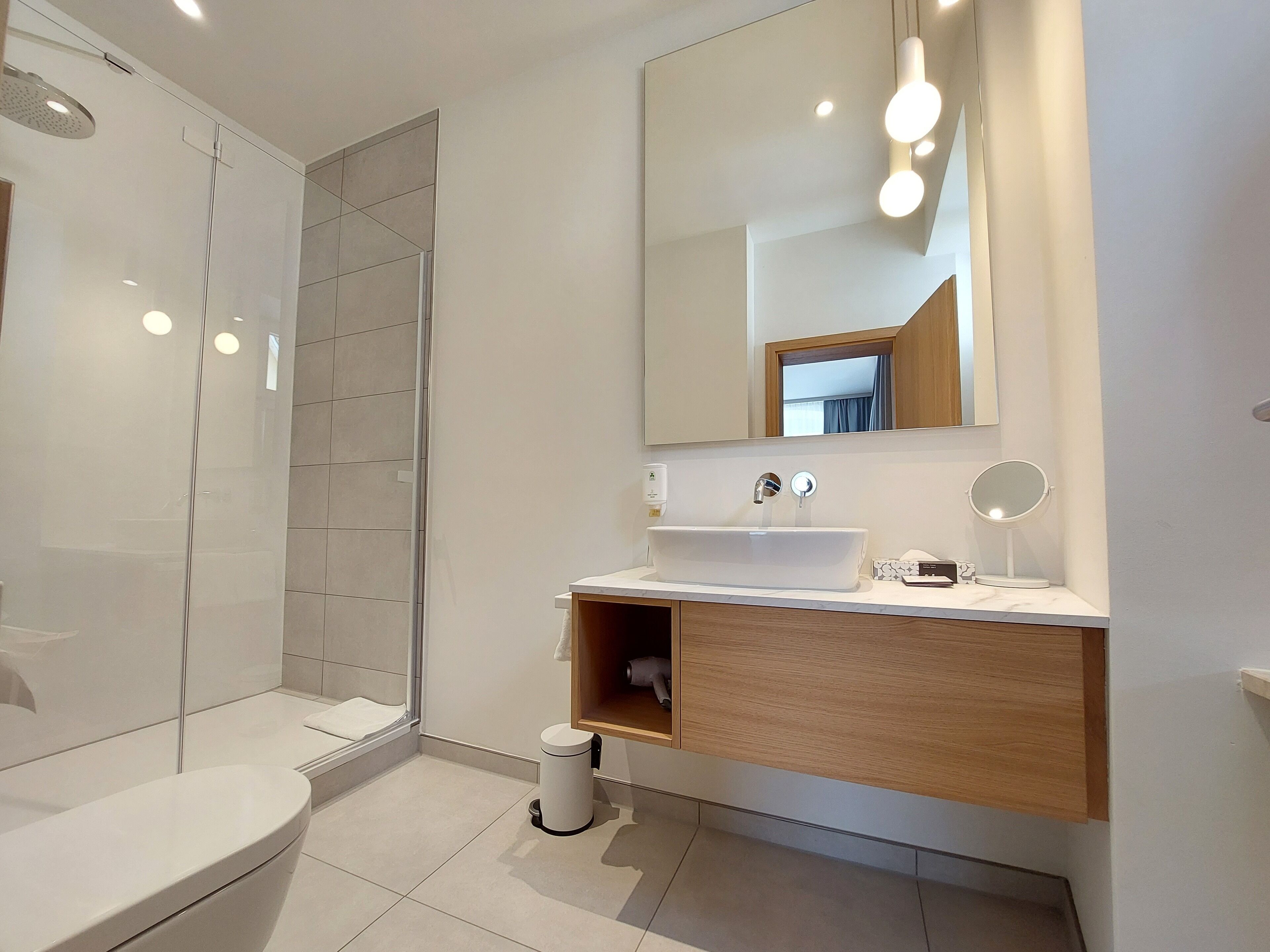 Un baño moderno con ducha, inodoro, lavabo y tocador.