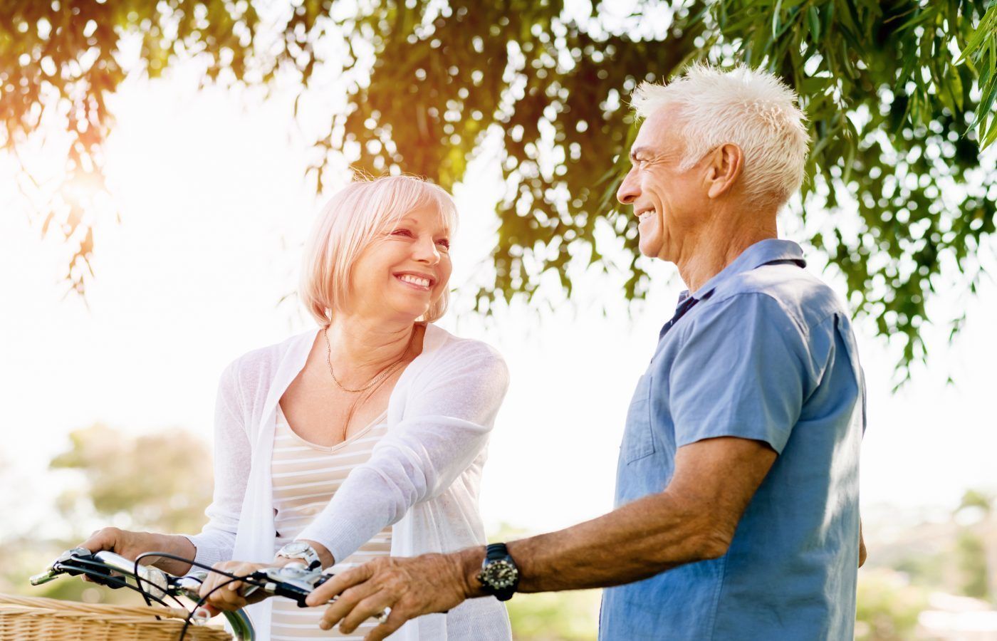 Two people standing outdoors, one holding a bicycle.