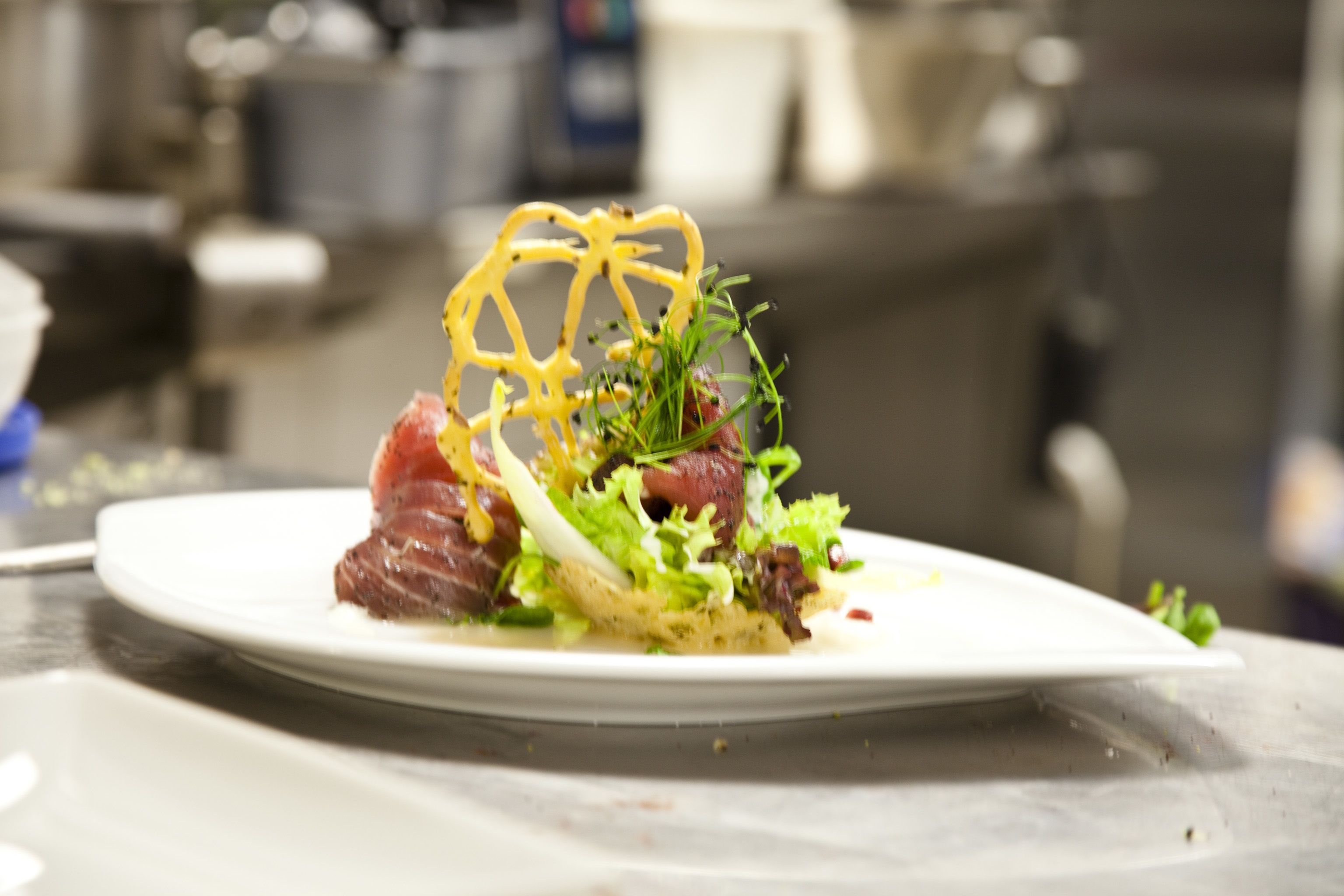 A plate of food with a focus on the dish, and a blurred background of a kitchen setting.