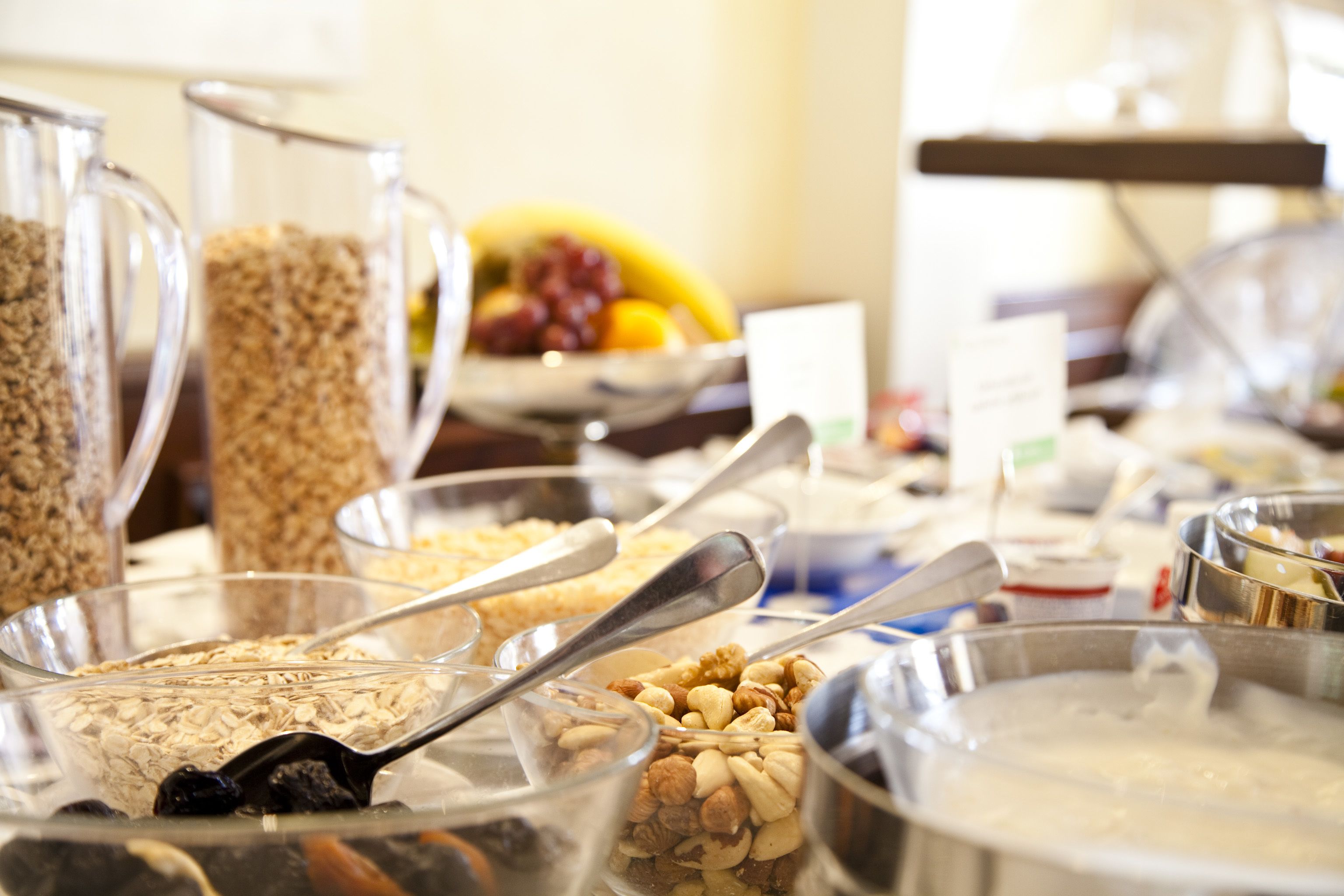 A buffet with various food items including cereals, nuts, and fruits.