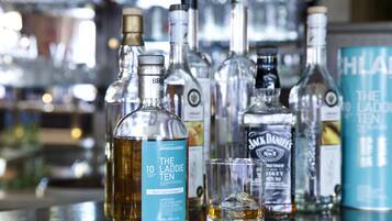 A bar with various bottles of alcohol, including a prominent bottle of The Laddie Ten whisky.