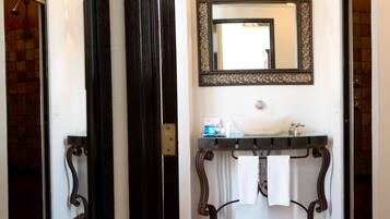 A bathroom with a white sink, a mirror, and a towel rack.