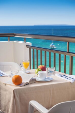 Una mesa lista para el desayuno con vista al océano.