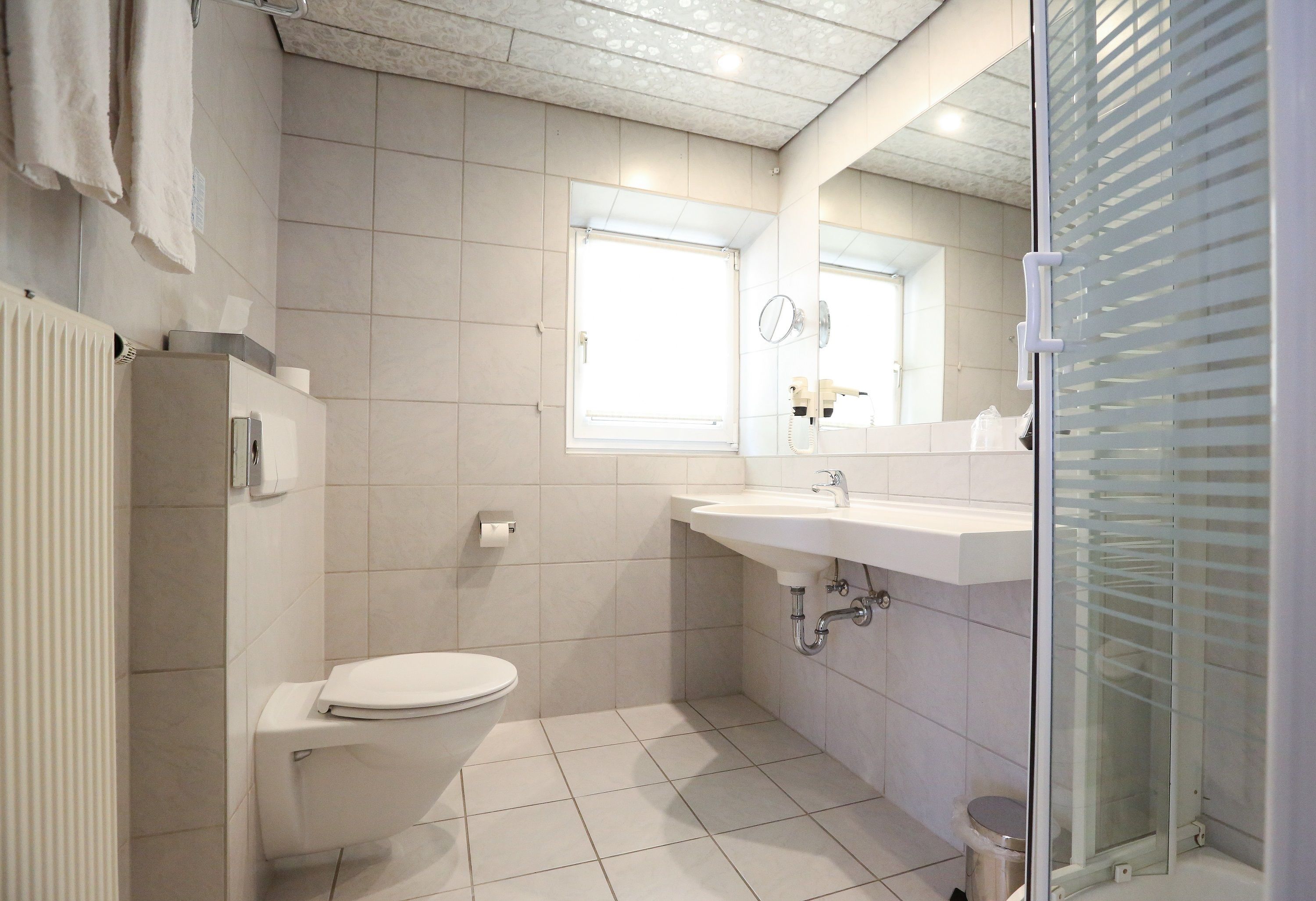 Une salle de bain moderne équipée de toilettes, d’un lavabo et d’une douche.