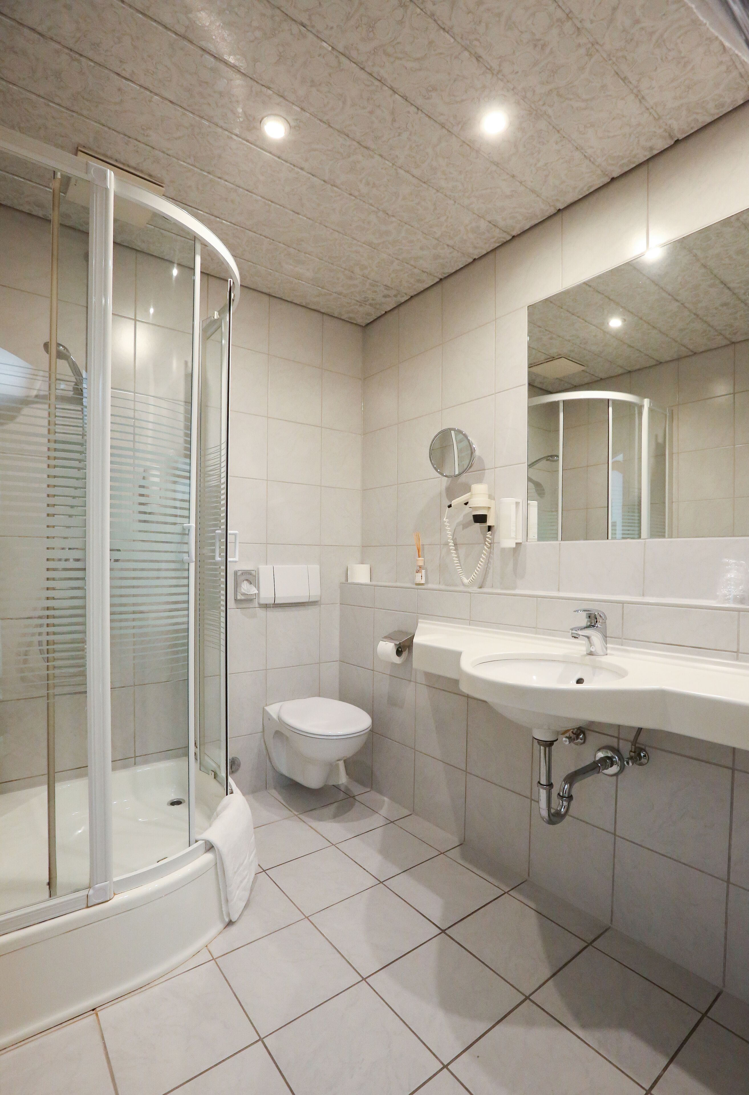 Ein modernes Badezimmer mit einer Duschkabine, einer Toilette und einem Waschbecken.