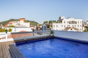 Una piscina al aire libre, sombrillas, tumbonas