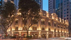 Un edificio histórico con arquitectura clásica, ventanas grandes y una fachada bien iluminada.