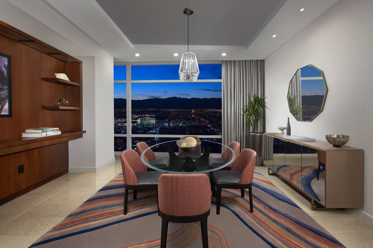 Un comedor moderno con una mesa redonda de vidrio, seis sillas y vistas a un paisaje urbano al anochecer.