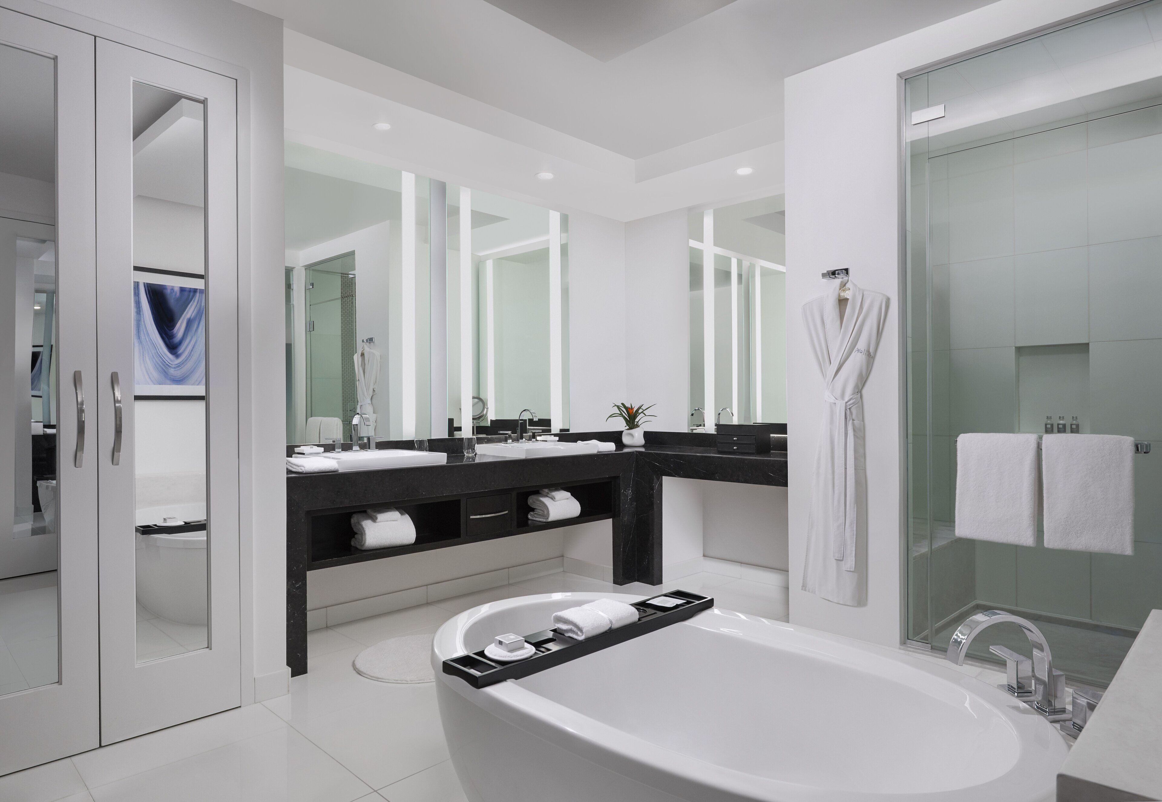 A modern bathroom with a freestanding bathtub, a glass-enclosed shower, and a vanity with a mirror and sink.