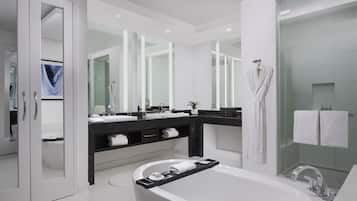 A modern bathroom with a freestanding bathtub, a glass-enclosed shower, and a vanity with a mirror and sink.