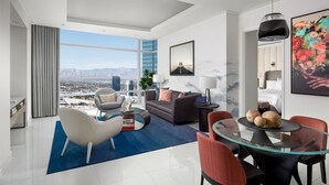 A modern living room with a city view, a glass dining table, and contemporary furniture. - ARIA Sky Suites (Las Vegas)