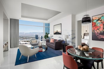 A modern hotel room with a large bed, a desk, a chair, and a TV. The room has a city view. at ARIA Sky Suites