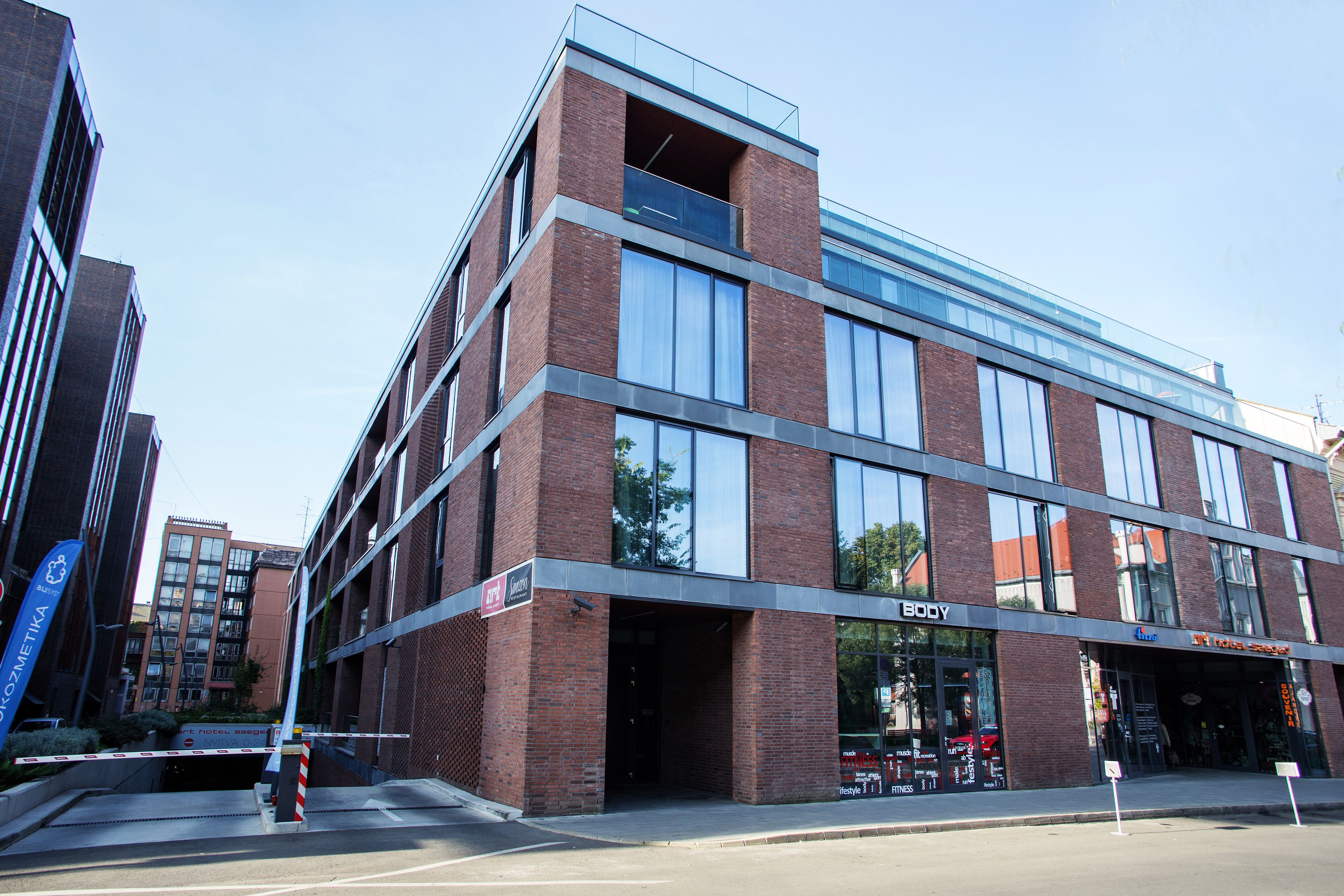 A modern building with a glass facade and a sign for 'BODY' on the ground floor.