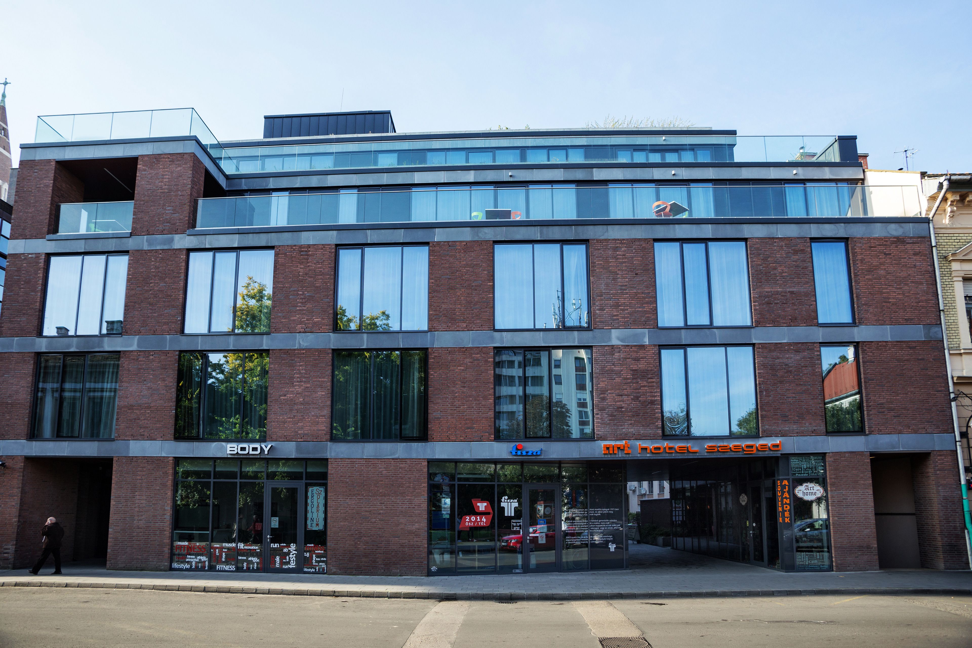 A modern building with a fitness center named 'BODY' and a hotel named 'ARK HOTEL'.