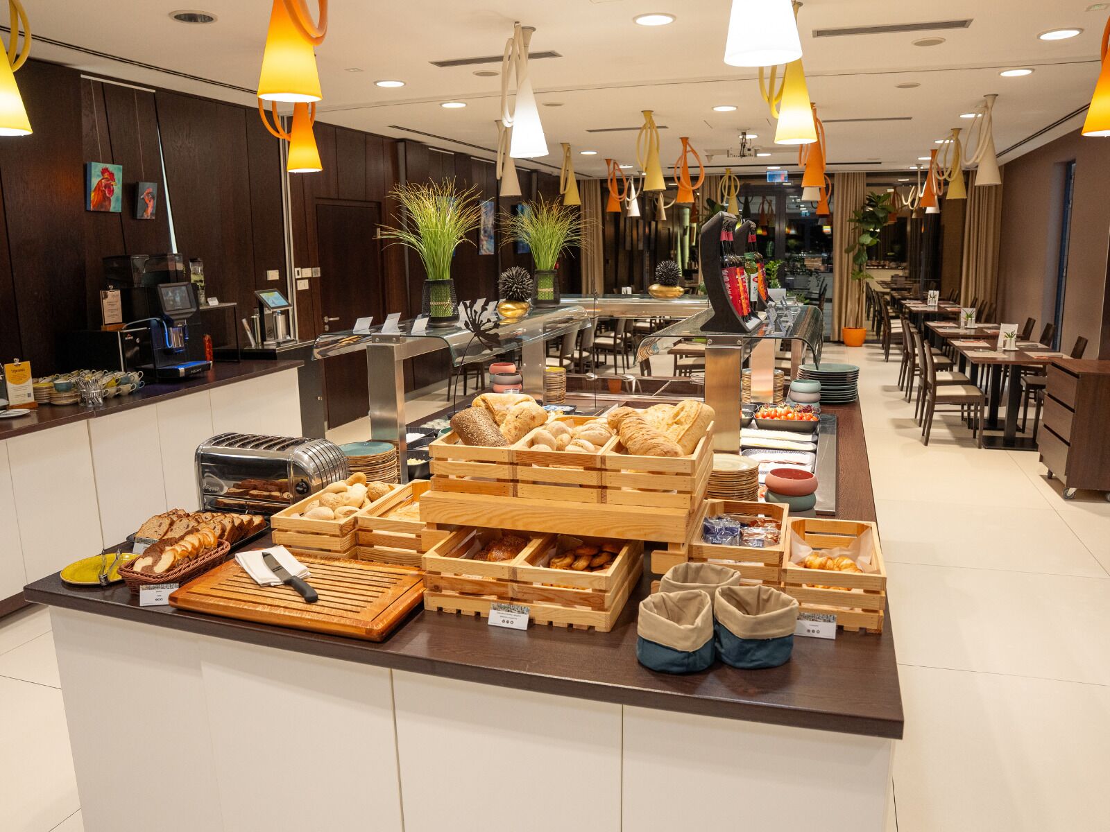 A buffet area with various food items, a coffee machine, and a seating area with tables and chairs.