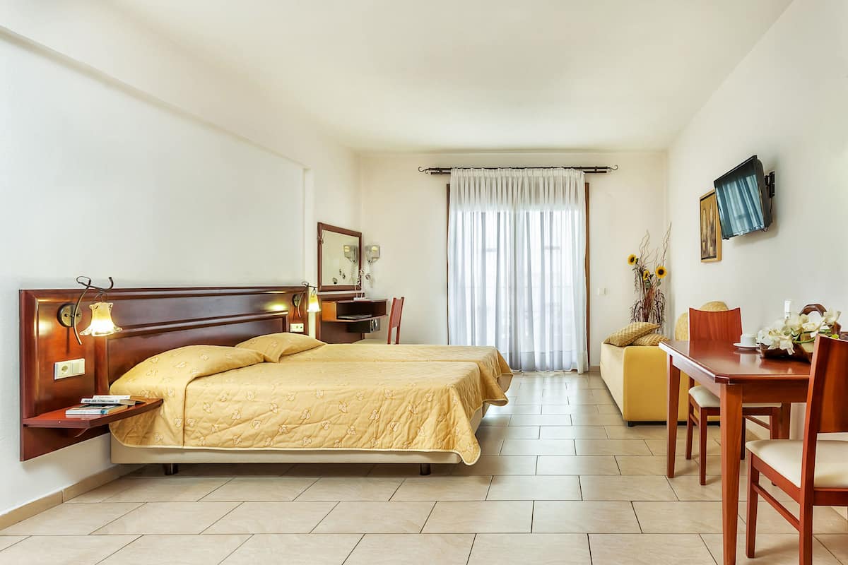 Une chambre d’hôtel avec un grand lit, des tables de chevet, un bureau et une chaise.