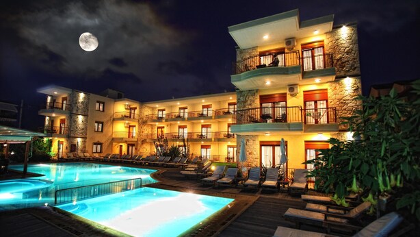 Un hôtel doté d’une piscine, de nombreux balcons et où l’on peut admirer la lune dans le ciel.