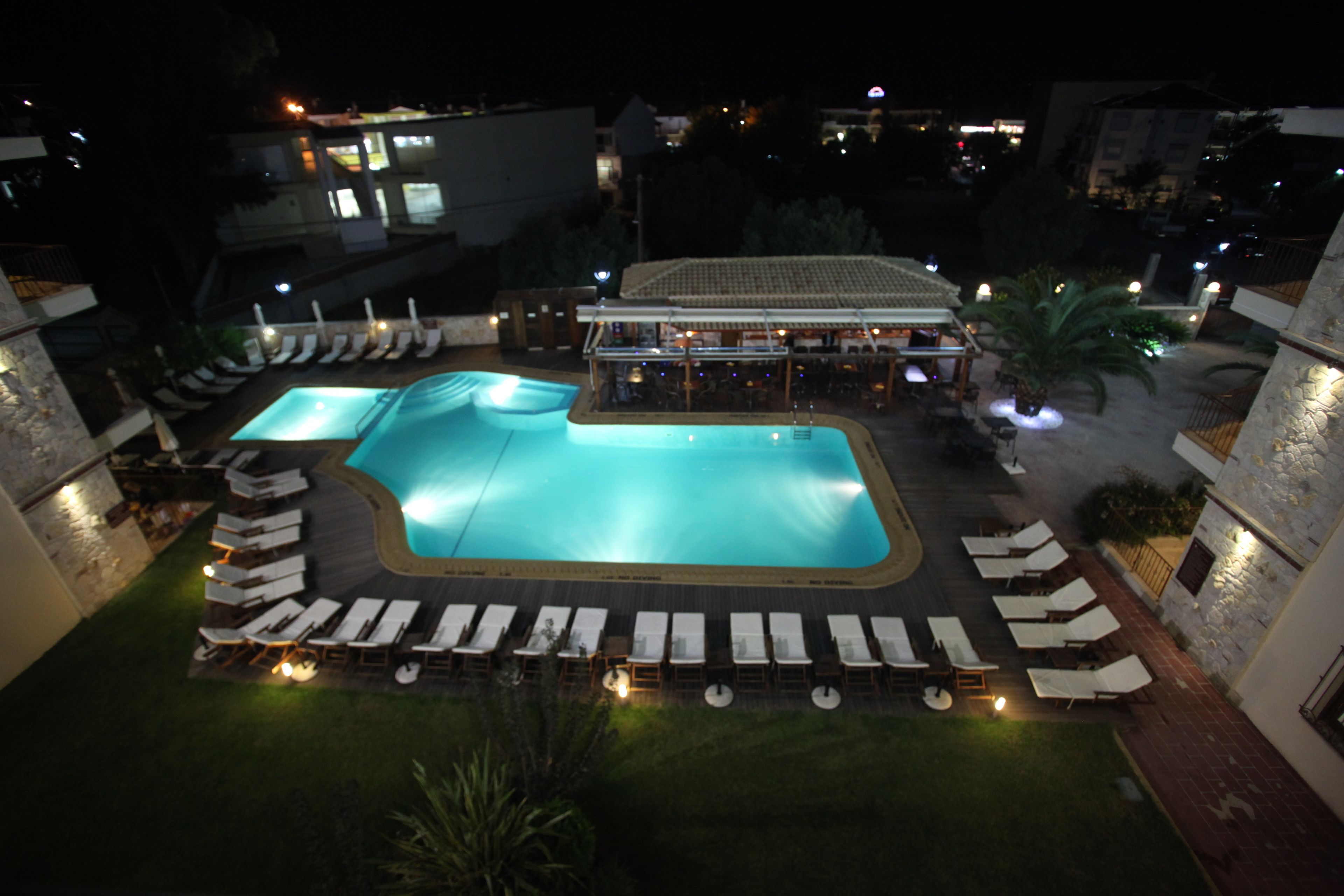 A rooftop pool area with sun loungers and a bar.