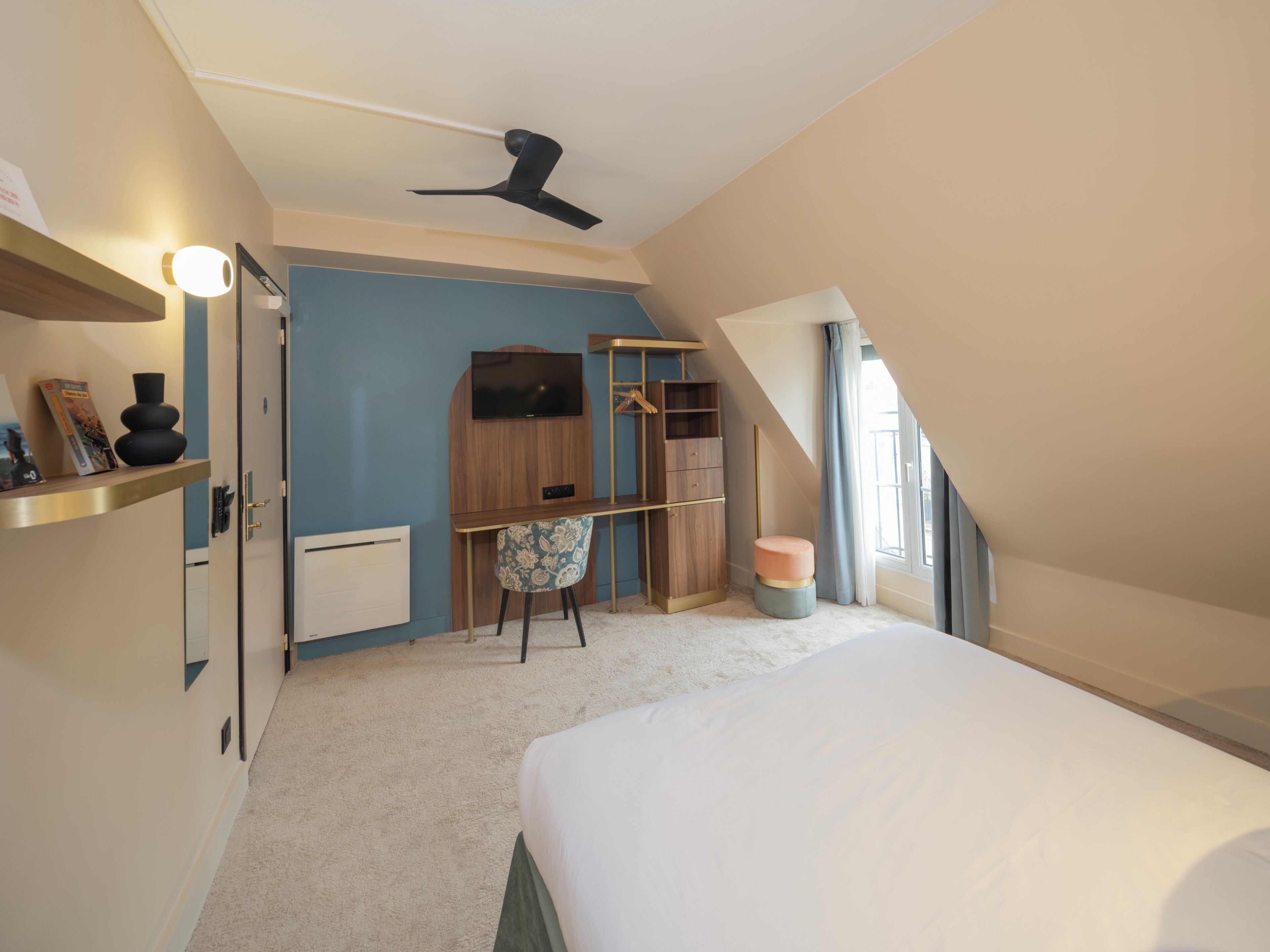 Une chambre à coucher comprenant un lit, un bureau, une chaise, une armoire et un ventilateur de plafond.