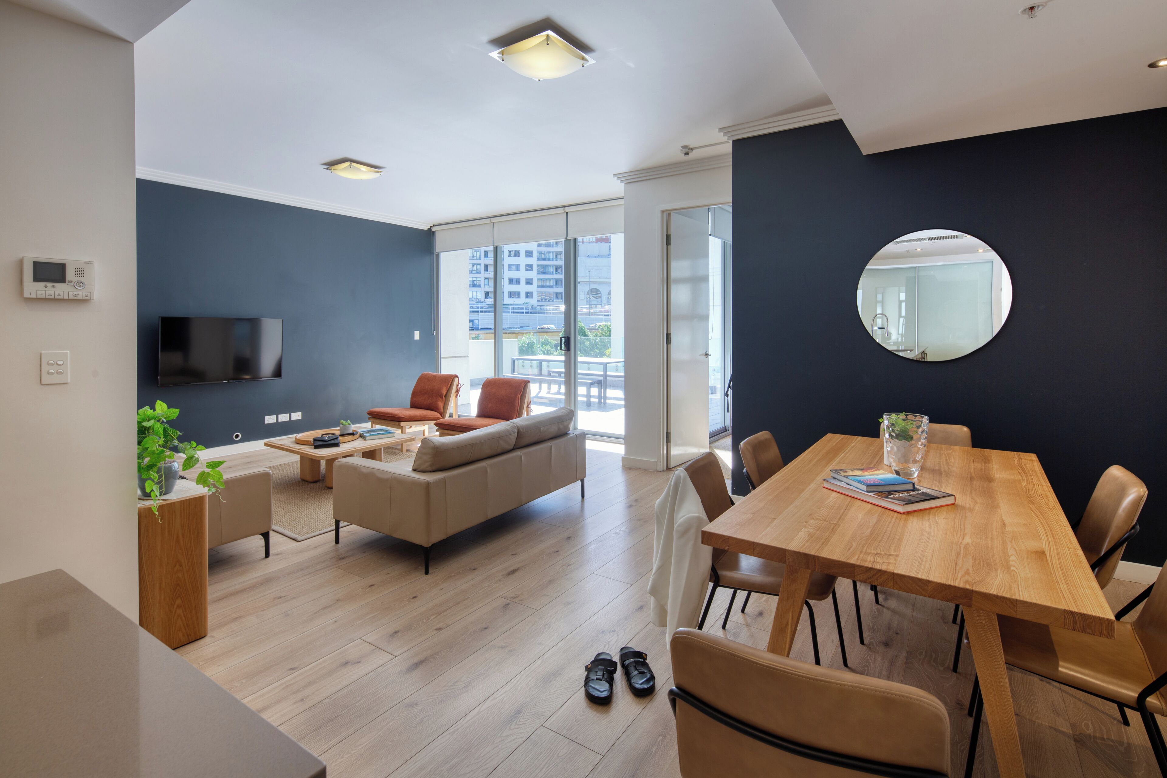 A modern living room with a sofa, coffee table, and dining table.