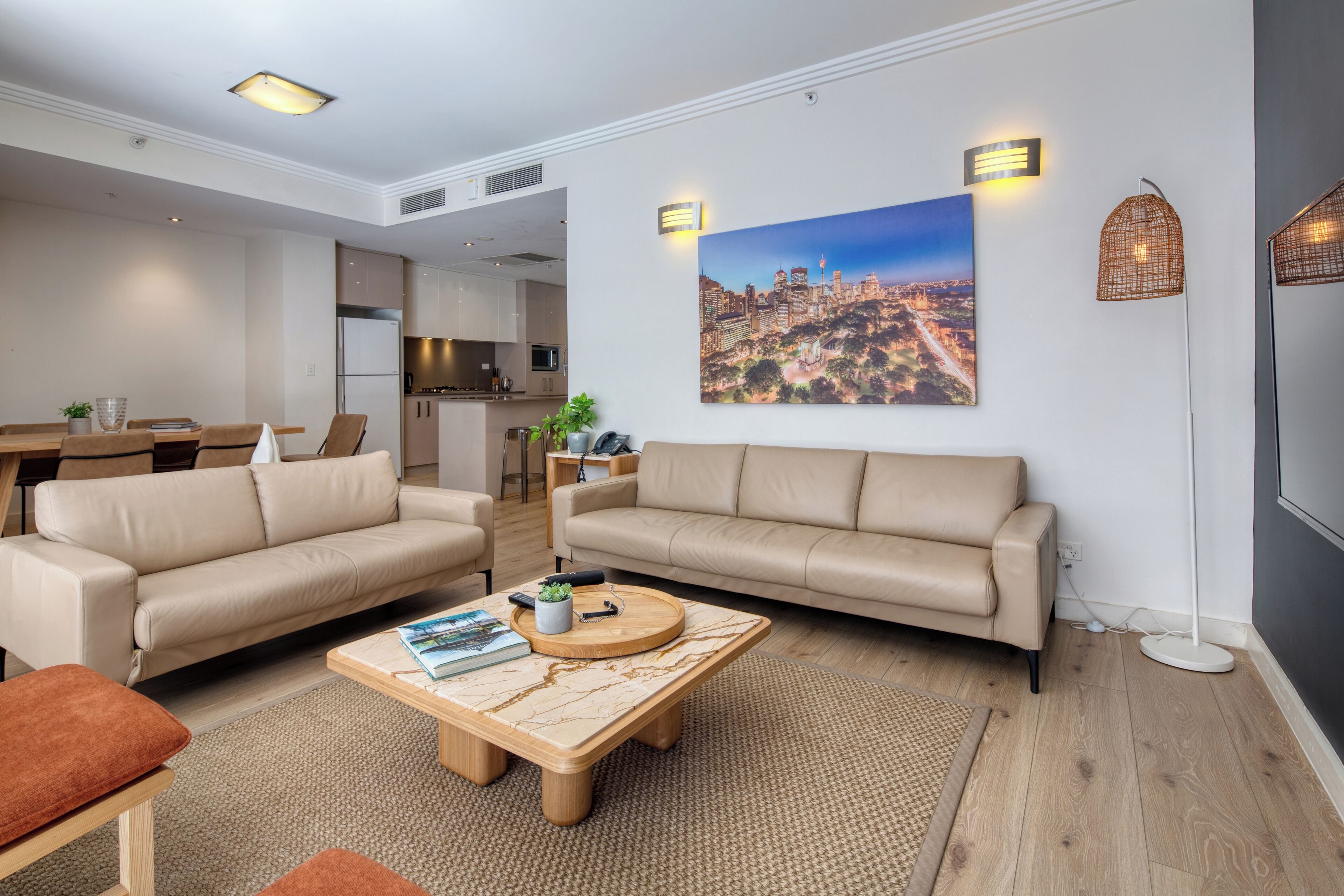 Uma sala de estar moderna com dois sofás, uma mesa de centro e um espaço de jantar.