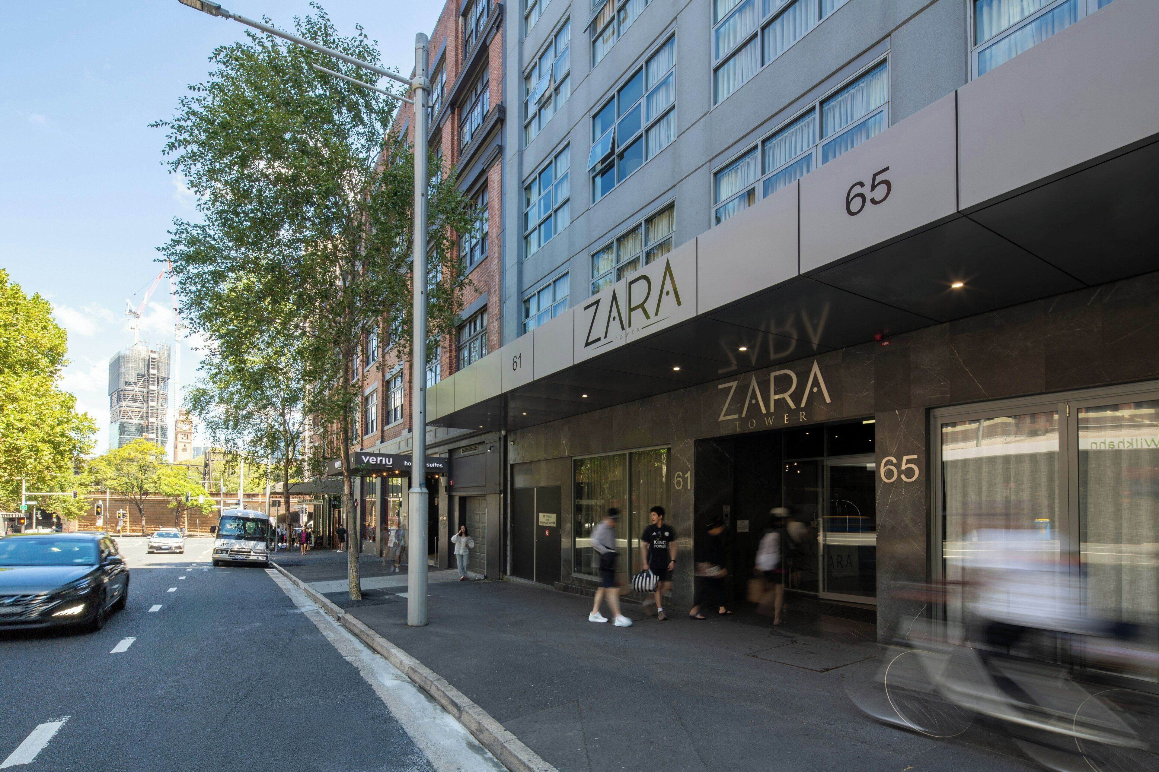 Una tienda Zara con fachada moderna, ubicada en una concurrida calle urbana.