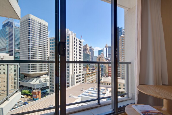 A high-rise hotel room with a large window offering a city view.