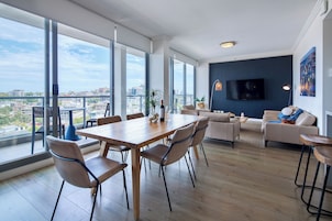 Ett rymligt vardagsrum med ett matbord, stolar, en soffa och en TV.