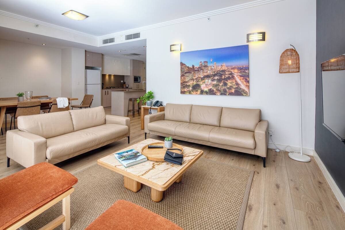 A modern living room with a sofa, coffee table, and dining area.