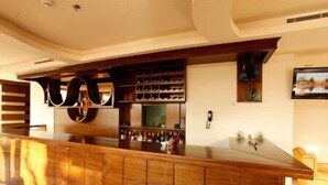 A bar area with wooden paneling and a wine rack. - Hotel Le Noble (Zouk El Kharab)