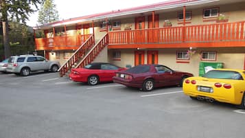 Un motel con facciata rossa, diversi balconi e una scala che conduce al piano superiore.