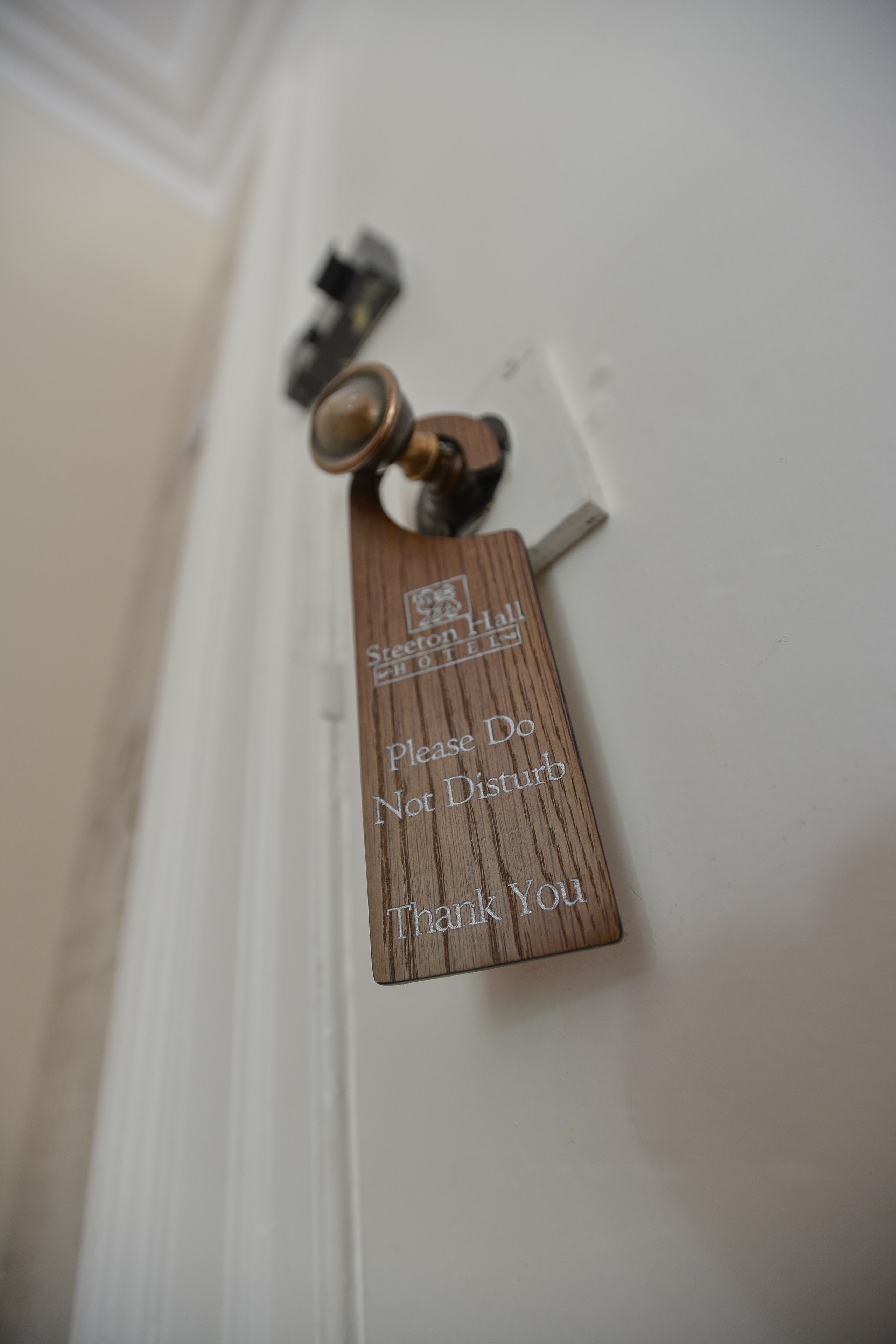Une sonnette en bois avec une pancarte indiquant : « Merci de ne pas sonner. »