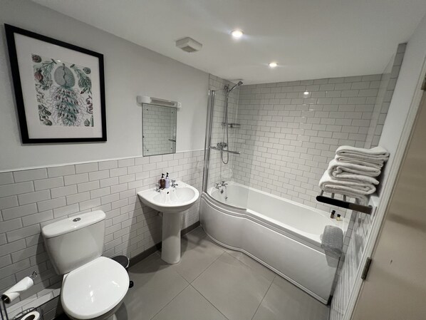 A bathroom with a toilet, sink, and bathtub.