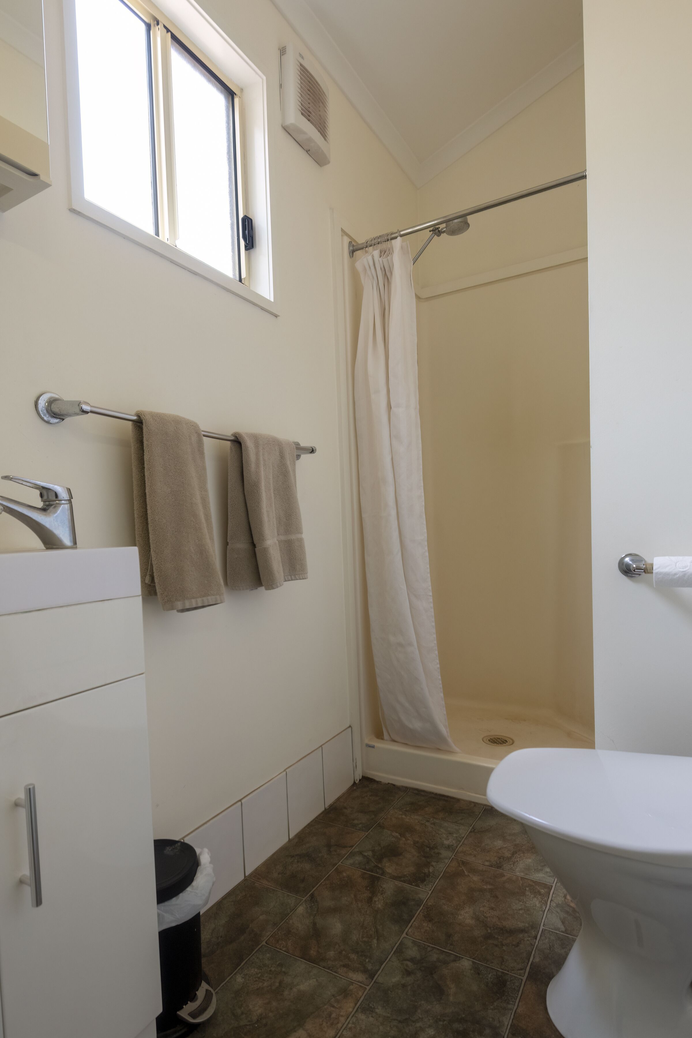 A bathroom with a shower, toilet, and sink.
