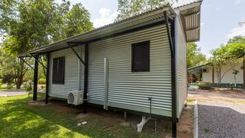 A single-story mobile home with a metal exterior, a covered porch, and a small attached garage.