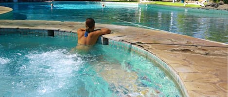 Una piscina al aire libre, sillones reclinables de piscina