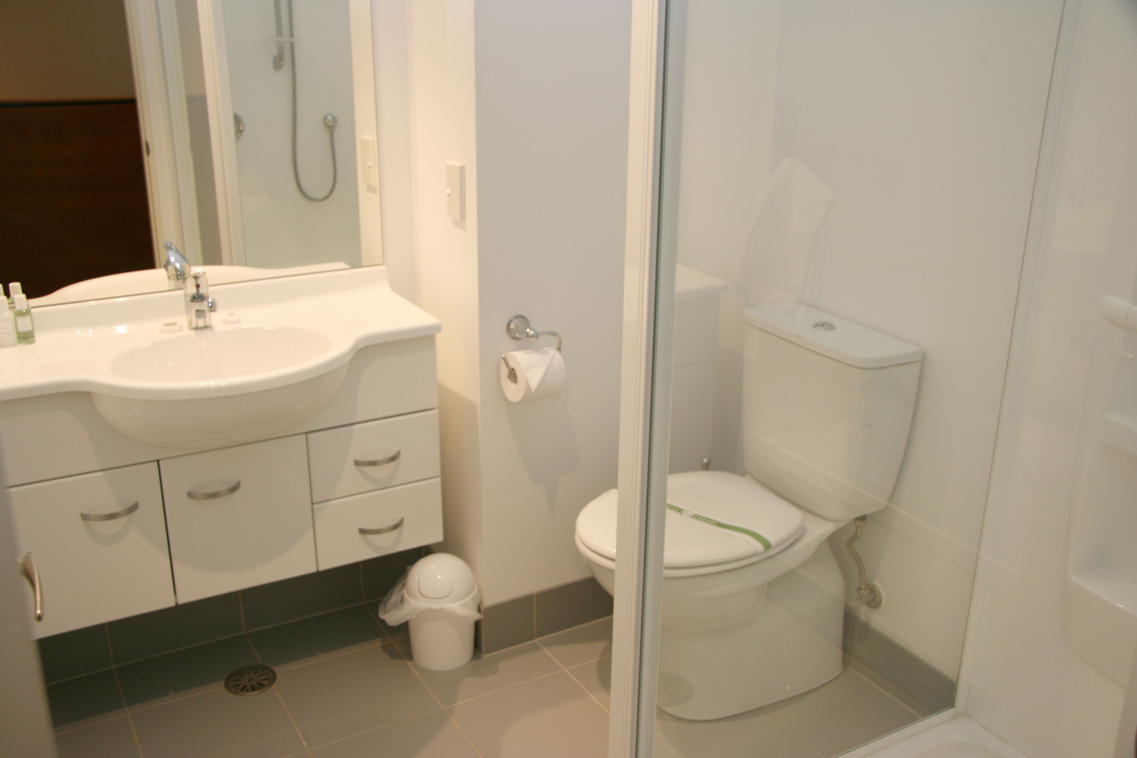 A bathroom with a sink, toilet, and shower area.