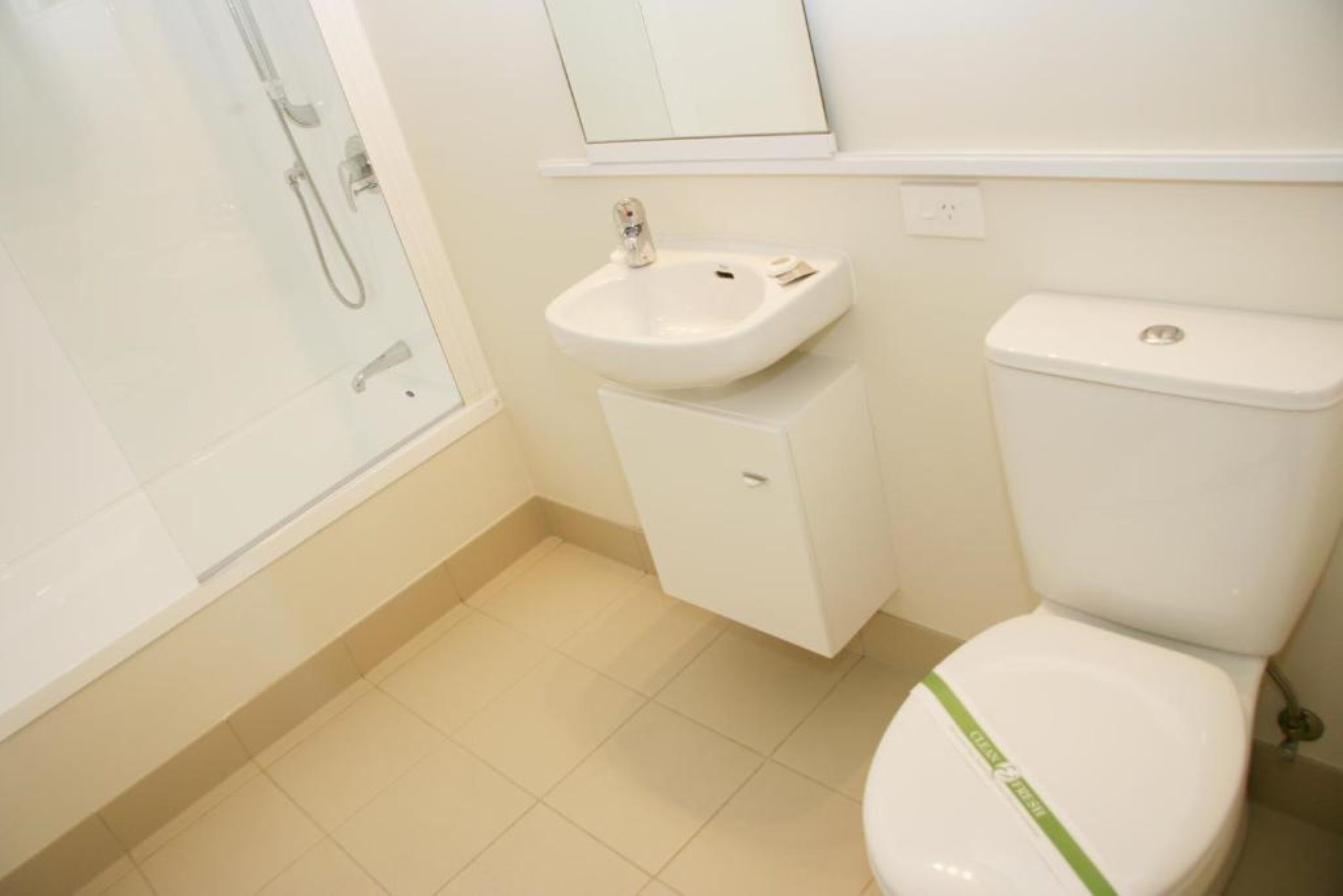 A bathroom with a toilet, sink, and shower.