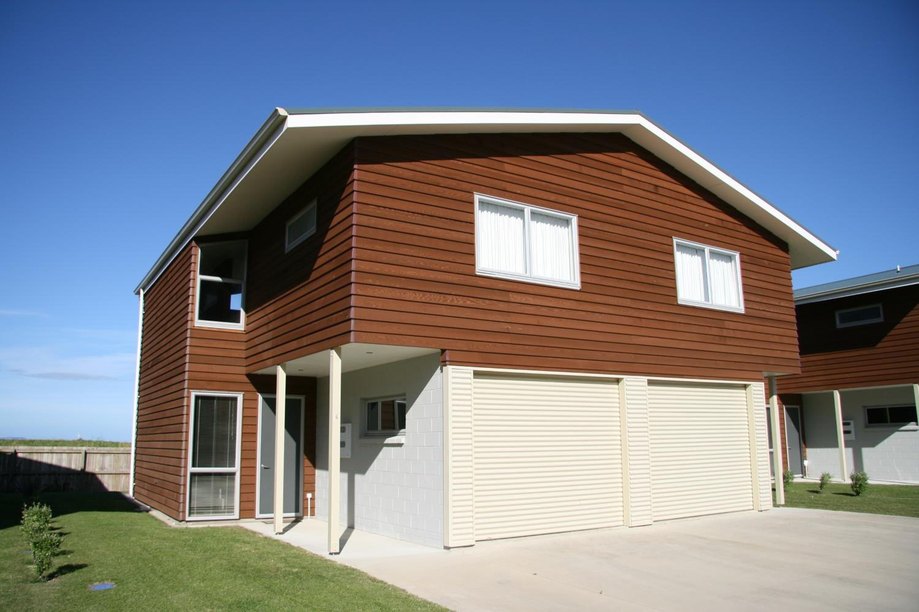 A two-story house with a garage, a covered porch, and a small lawn.