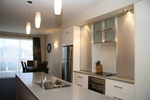 Een koelkast met diepvriezer, een microgolfoven, een kookplaat