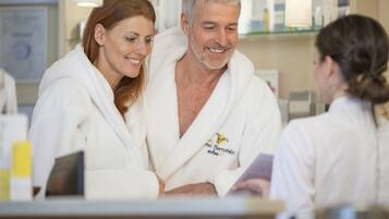 Un cadre professionnel où l’on voit des personnes vêtues de robes blanches, probablement dans un spa ou un centre de bien-être.