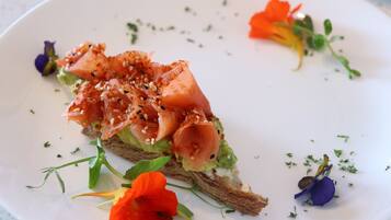 Un plato con un sándwich, adornado con hierbas y flores.