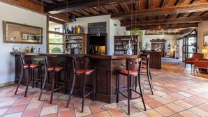 A bar area with wooden bar stools, a counter with a chalkboard menu, and a large mirror on the wall. - Hotel Engel (Hamburg)