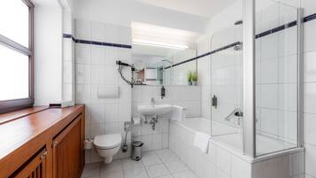 A modern bathroom with a toilet, sink, and glass-enclosed shower.