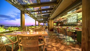 An indoor restaurant with glass ceilings, wooden furniture, and a view of the sunset. - Lasagrada Hotel Istanbul (Istanbul)