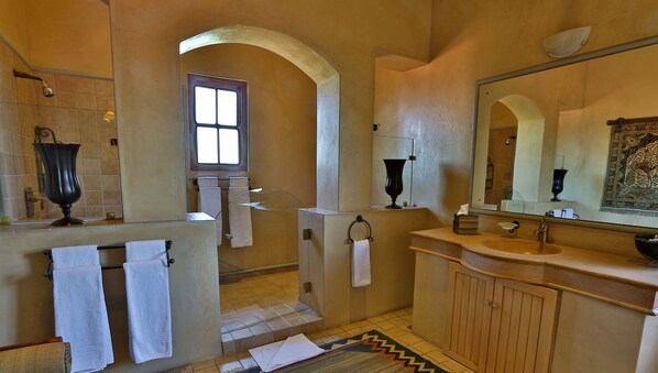 A bathroom with a large mirror, a sink, a shower, and a window. - Castello di Monte (Pretoria)