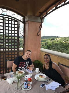 A couple dining at a table with a view of a lush landscape. - Castello di Monte (Pretoria)
