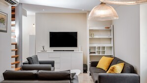 A modern living room with a flat-screen TV, grey sofas, and a white entertainment unit. - Bouganvillea Split Apartments (Split)