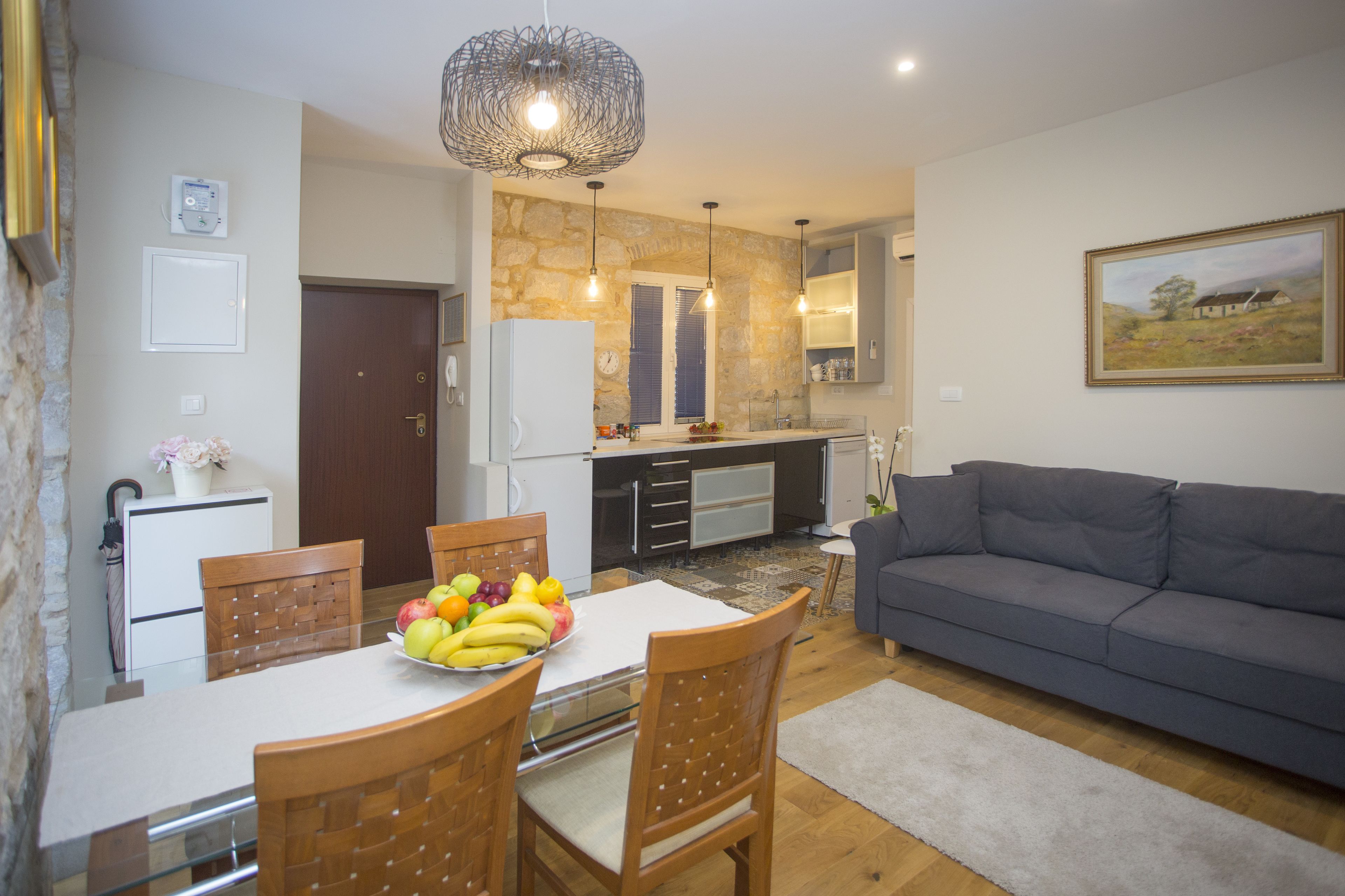 A compact living space with a dining area, kitchenette, and a sofa.